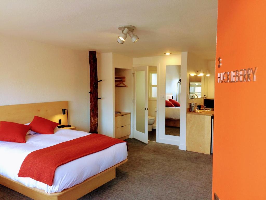 贝灵厄姆Heliotrope Hotel的一间卧室配有一张带红色枕头的床,还设有一间厨房