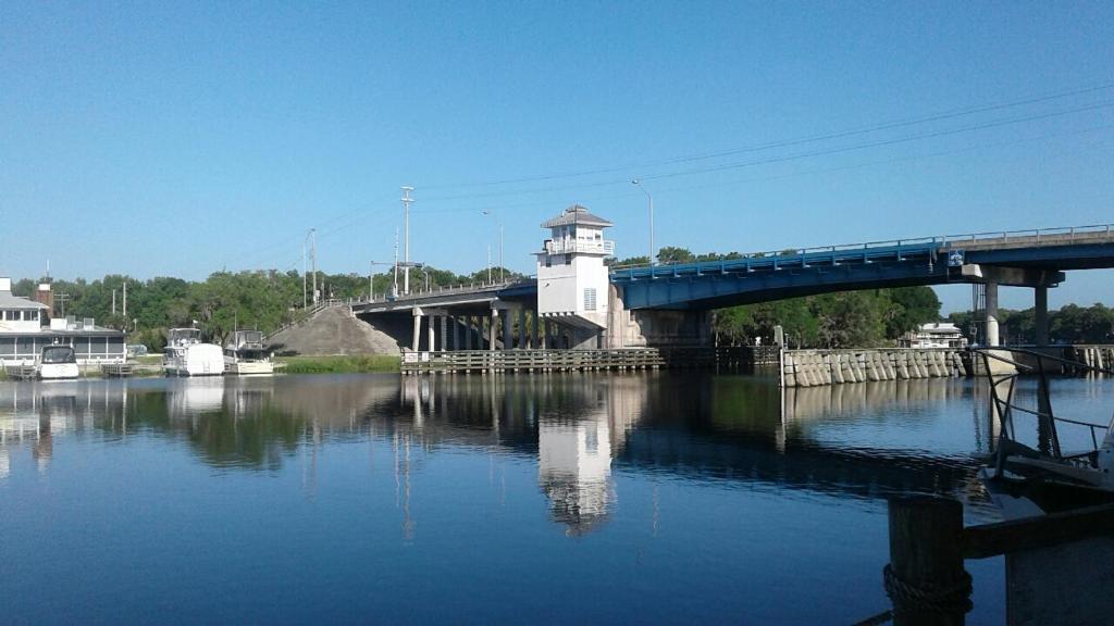 AstorBig River Marina & Lodge的一座桥,一座桥在河上,有灯塔和一座桥