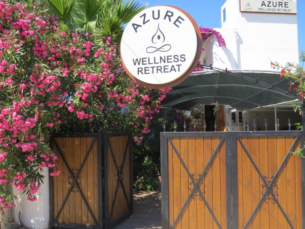 图尔古特雷斯Azure Wellness Retreat的粉红色花门上的健康度假标志