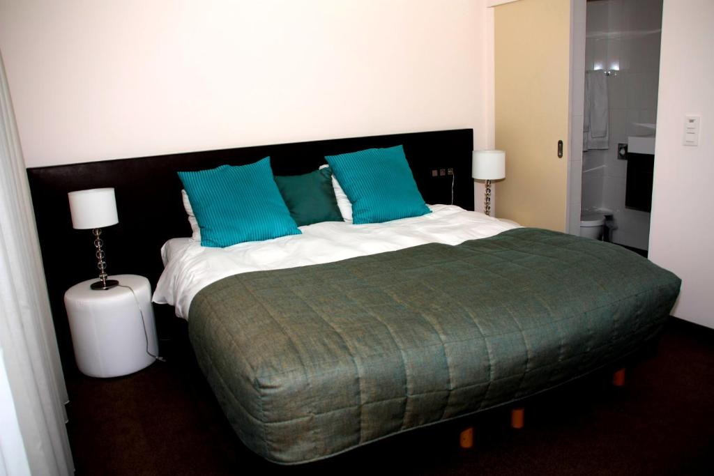 里姆斯特马博图斯酒店的一间卧室配有一张带蓝色枕头的大床