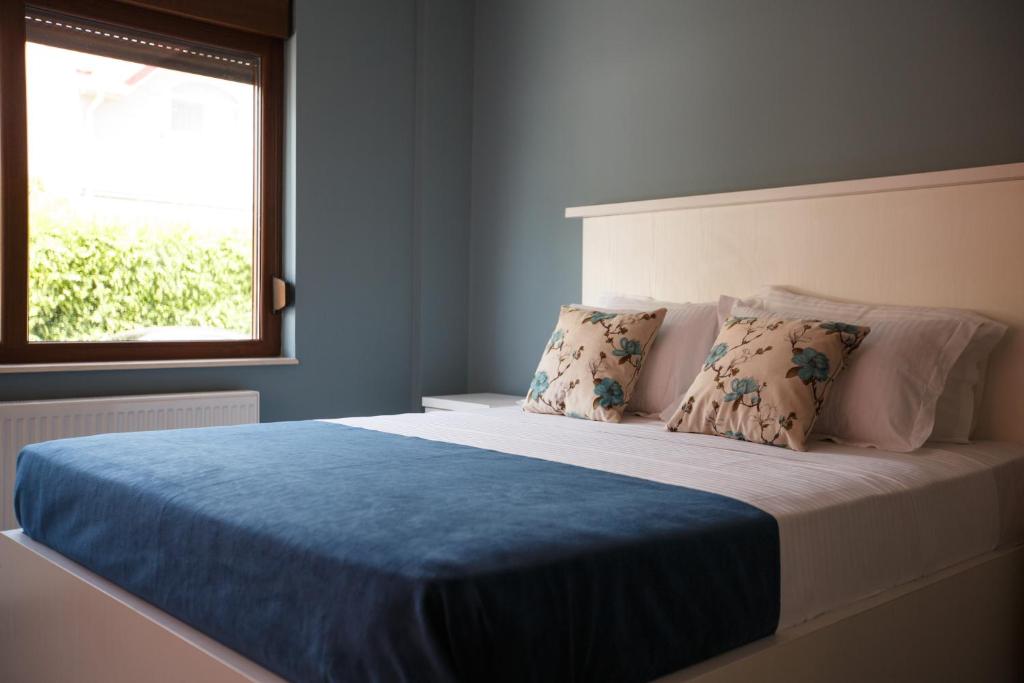 康斯坦察Bliss Residence - Aquamarine的一间卧室配有一张带蓝色毯子的床和窗户。