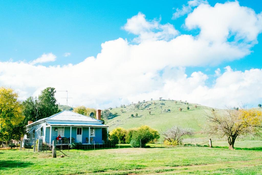 冈德盖奇摩农家乐的一座蓝色的房子,位于一个山丘的田野上