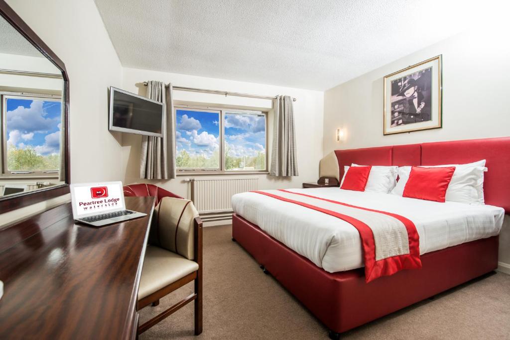 米尔顿凯恩斯皮尔屈水景旅馆的酒店客房配有一张床、一张书桌和一台笔记本电脑