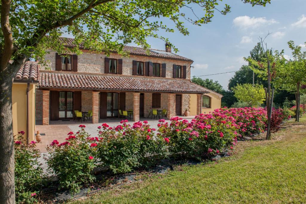 Castelbellino拉维奇亚丰堤农庄酒店的前面有粉红色花的房子