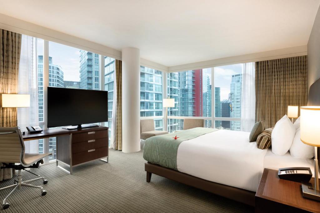 温哥华Coast Coal Harbour Vancouver Hotel by APA的一间酒店客房,设有一张大床和一个大窗户