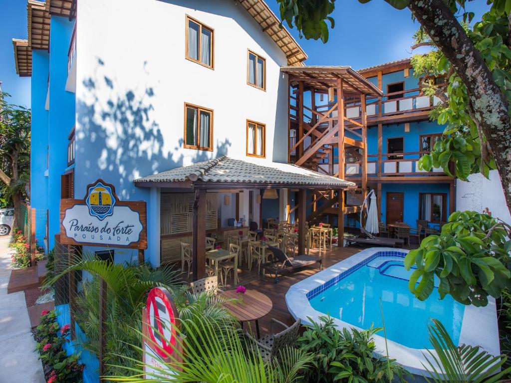 普拉亚多Pousada Paraíso do Forte的大楼前设有游泳池的酒店