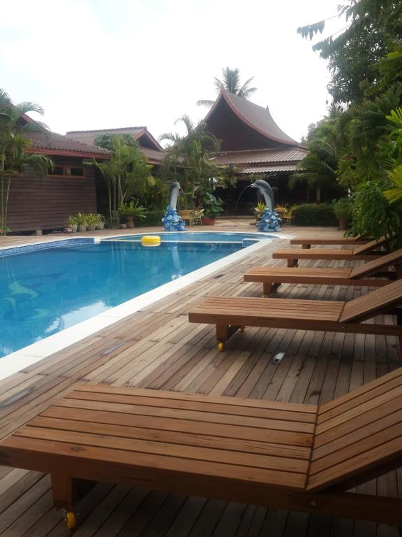 Ban Khon森加赫伦恩度假旅馆的游泳池旁的一排木凳