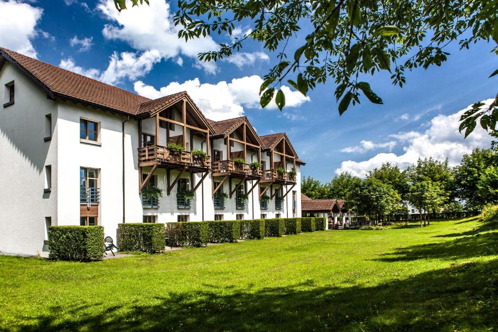阿尔邦西格腾酒店及餐厅 的一座白色的大建筑,有绿色的院子