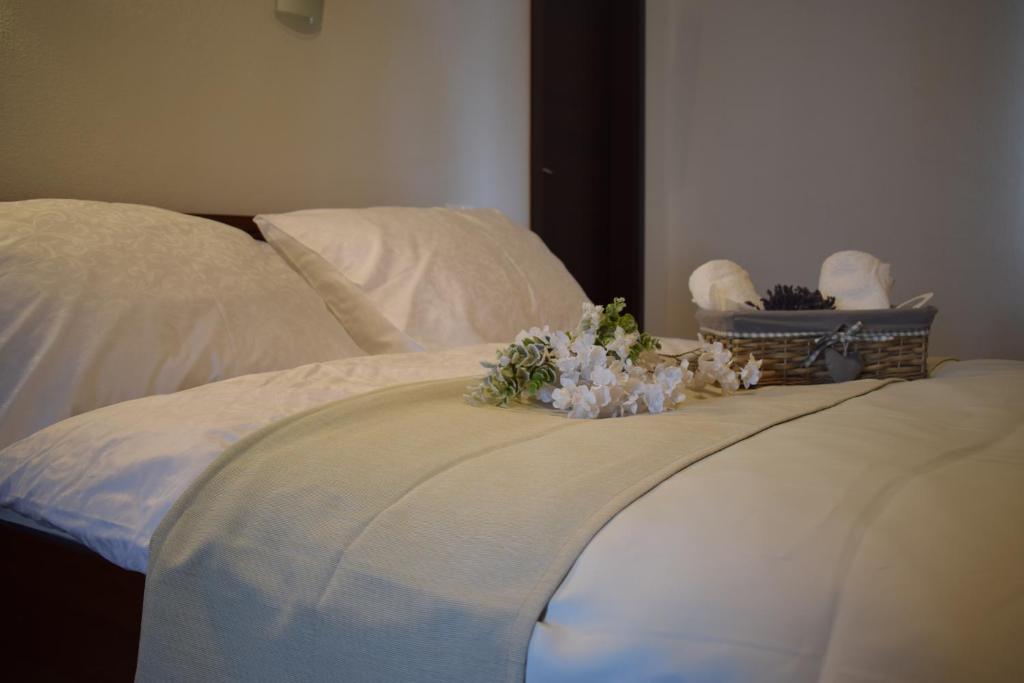 特尔纳瓦Saint Michael - Garni Hotel的一张铺有白色床单和鲜花的床
