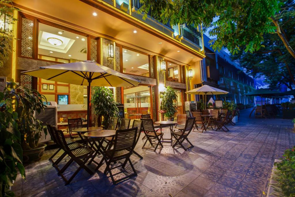 河内针叶树精品酒店的一个带桌椅和遮阳伞的户外庭院。