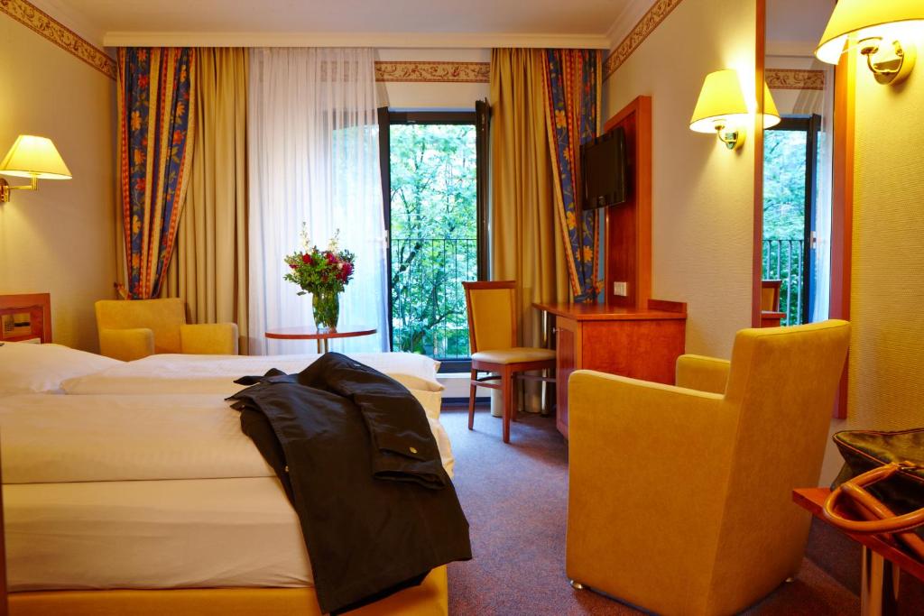 慕尼黑协和酒店的酒店客房,配有两张床和椅子