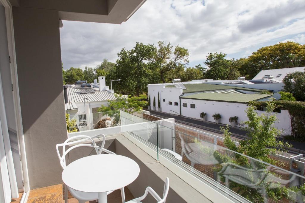 斯泰伦博斯Laanhof Studios的设有一个配有白色桌椅的阳台,享有美景。