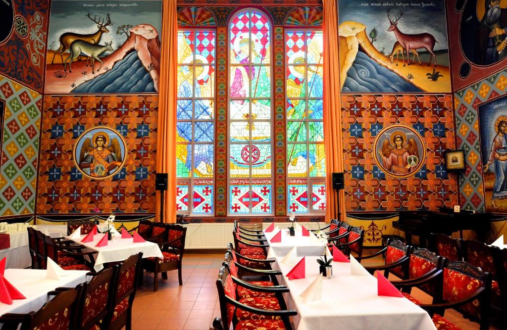 伊萨尔米Hotel Golden Dome Iisalmi的餐厅设有桌椅和彩色玻璃窗。