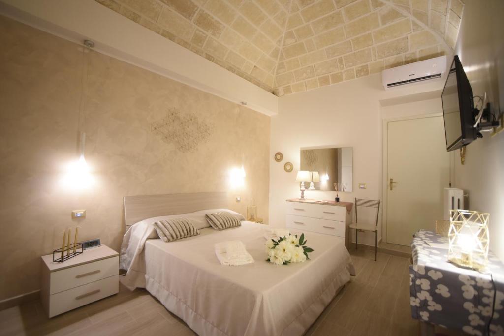 塔兰托CASA FELICE Maison de Charme的卧室配有带鲜花的白色床