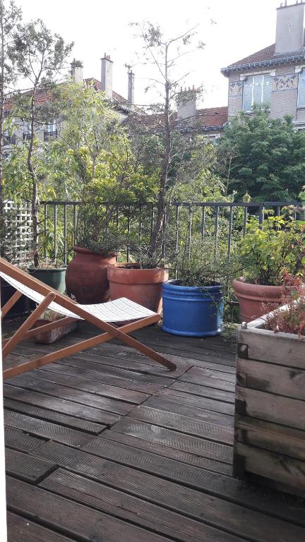 巴黎鸢尾花别墅旅馆 的木甲板上种有几株盆栽植物
