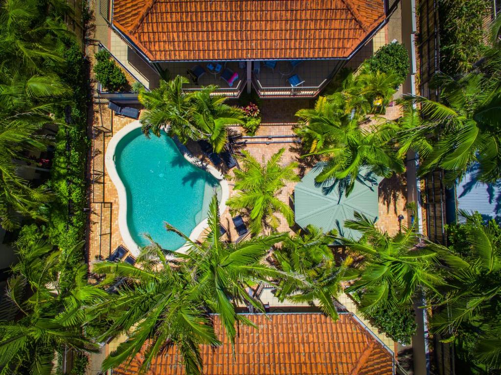 拜伦湾拜伦湾海滩公寓的享有带游泳池和棕榈树的度假村的顶部景致