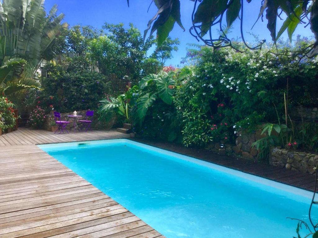 普纳奥亚Fare Sunny的花园内的游泳池,设有木甲板