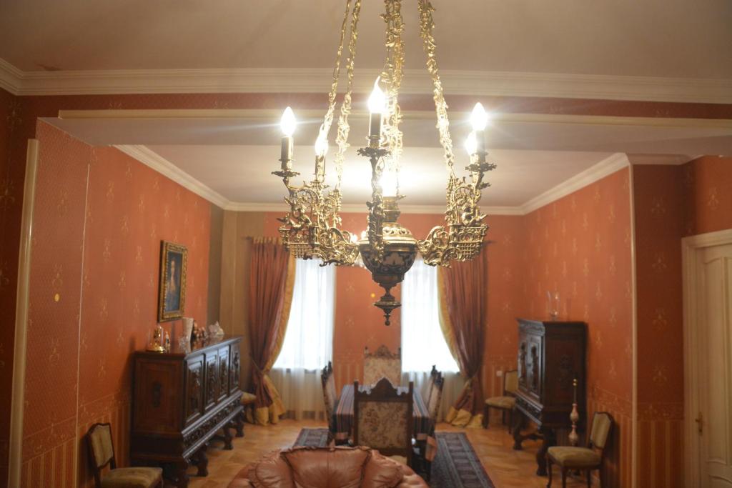 第比利斯Hotel Renesans的一间带吊灯的客厅和一间带椅子的房间
