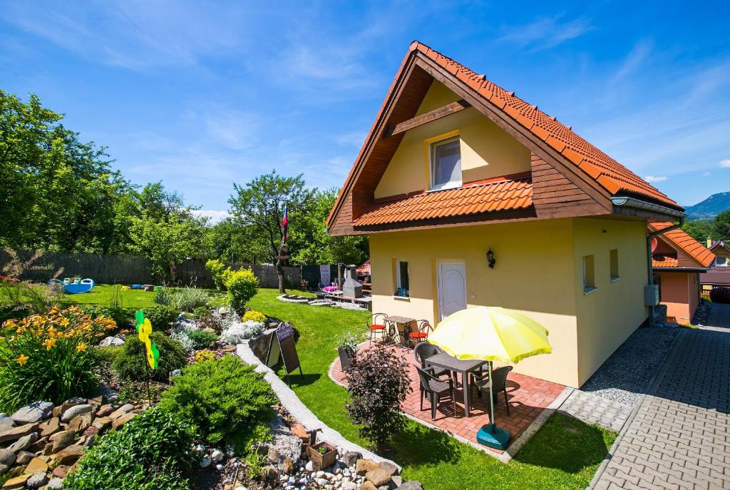 里托斯基挪威克Domceky Holiday的院子里的一个小黄房子,带雨伞