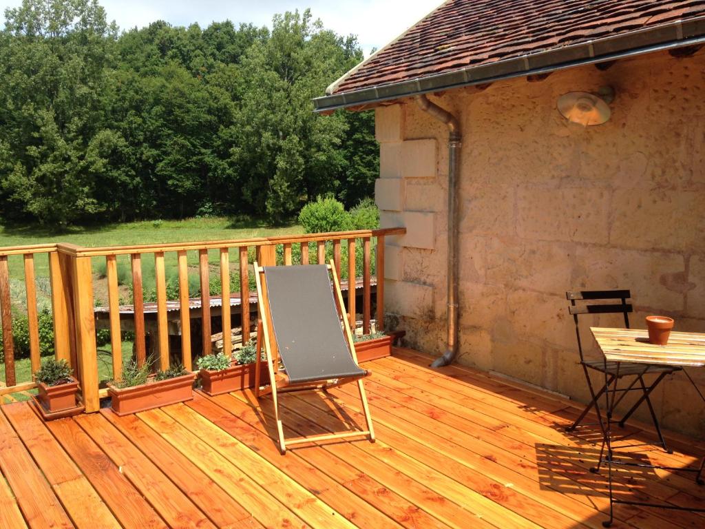Faverolles-sur-Cherstudio avec terrasse Abbaye d'Aiguevive的木制甲板上配有桌子和椅子