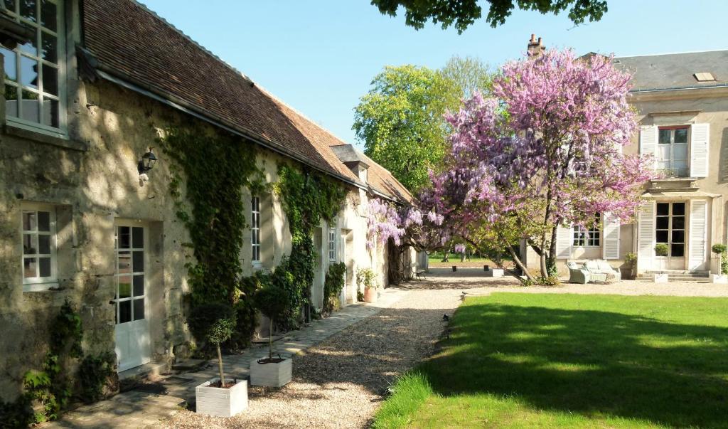 旺多姆Le Grand Saint-Marc的一座古建筑,有一棵紫色花卉树