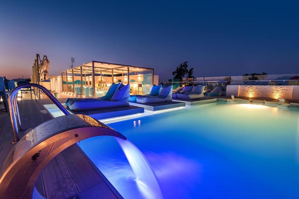 科斯镇玛丽提娜酒店的一座带蓝色枕头和沙发的游泳池