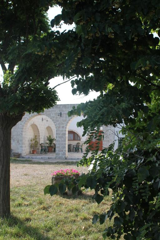 拉泰尔扎B&B Masseria Cappotto的石头建筑,有桌子和树