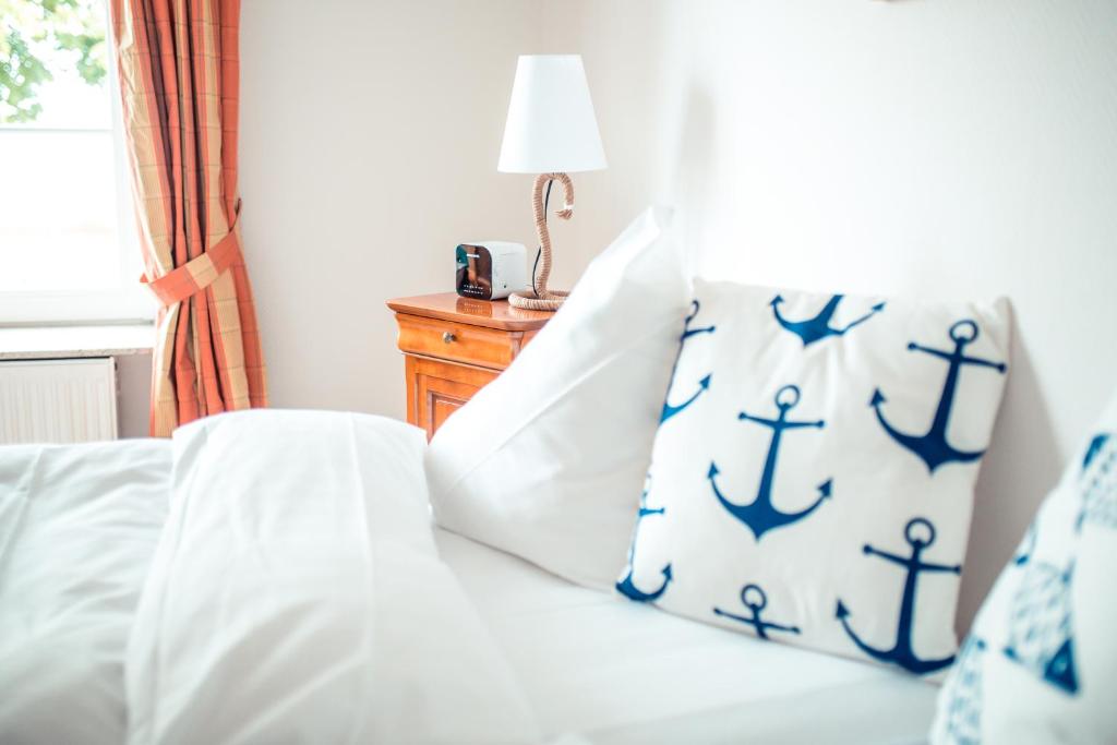 施特兰德Strandhotel Strande的一间卧室配有一张带蓝色和白色枕头的床