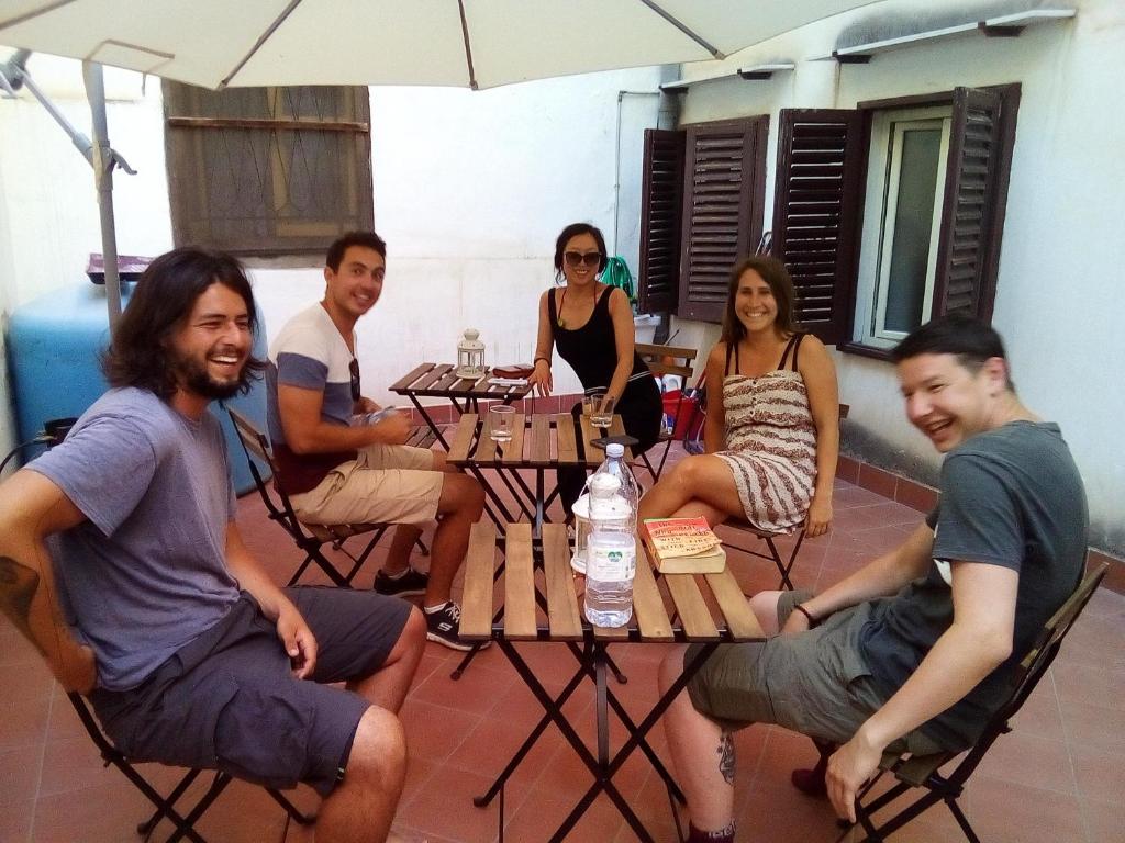 巴勒莫Sunshine Hostel Palermo的一群人坐在桌子旁
