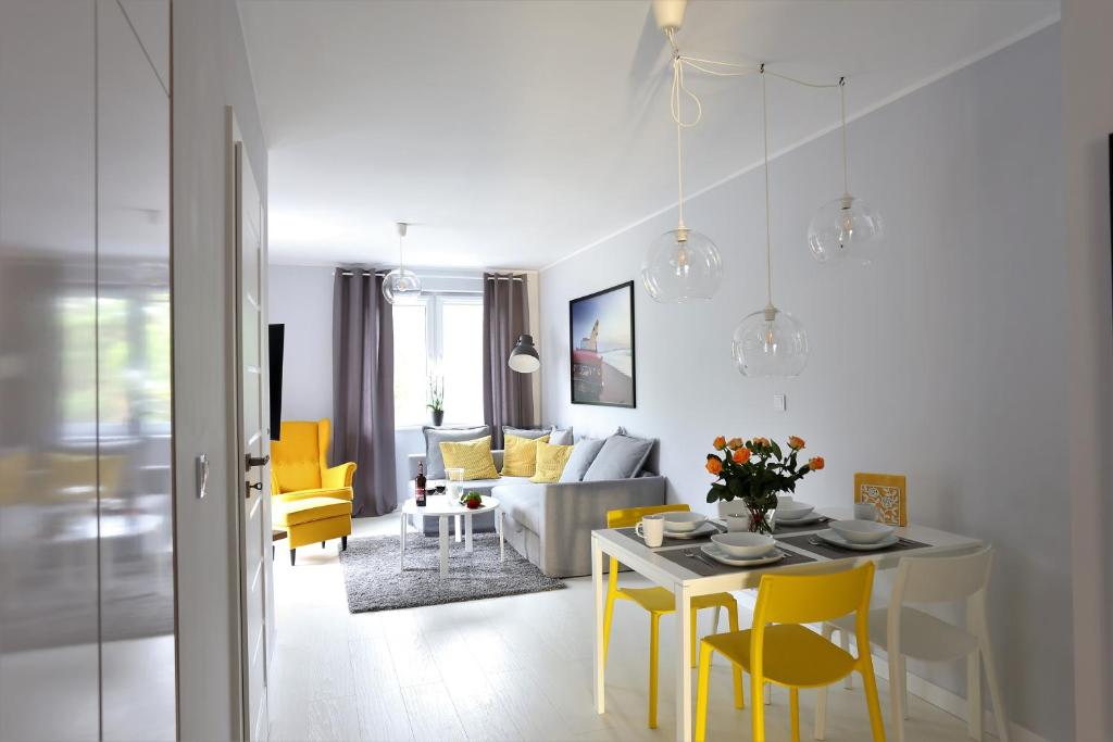 尤斯托尼莫斯基Apartamentowiec Dwie Sosny的客厅配有桌子和黄色椅子