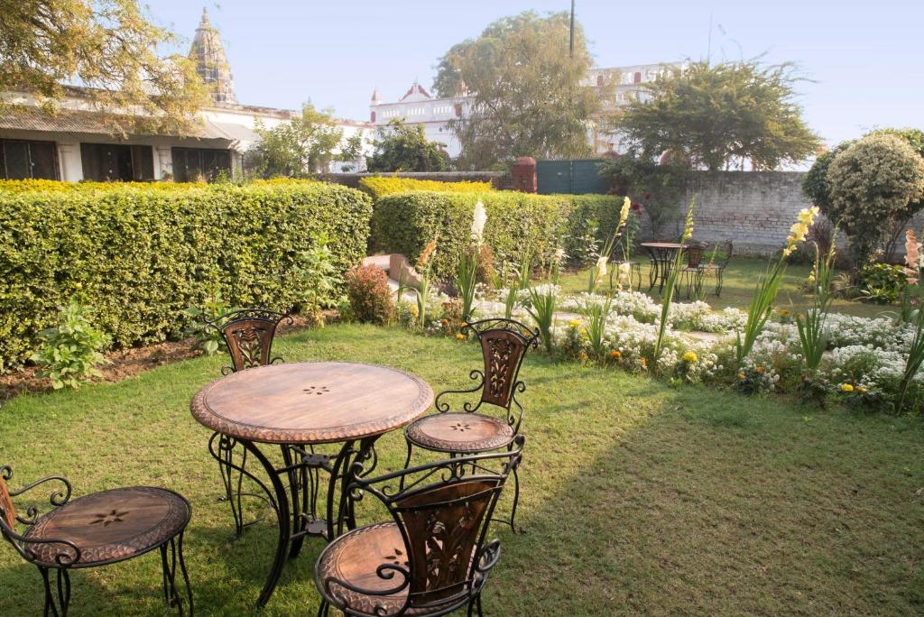 瓦拉纳西潘奇科特拉杰恒河住宿加早餐旅馆的一个带花园的庭院里的桌椅