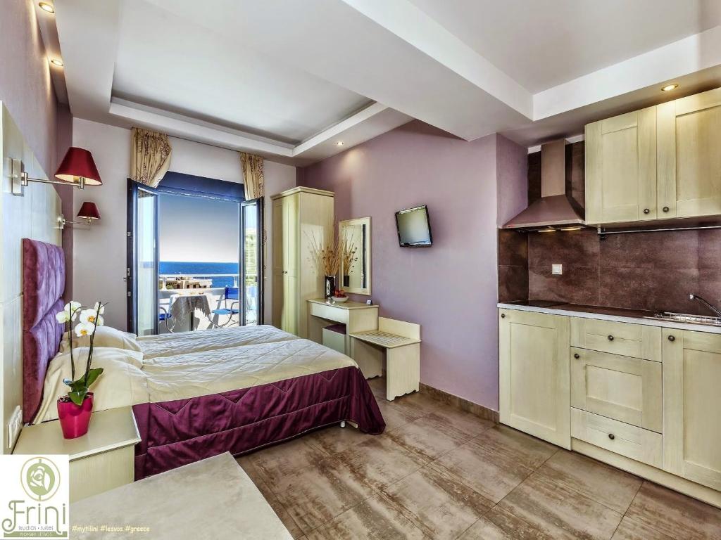普洛马里翁弗里尼一室公寓的一间卧室配有一张床,厨房享有美景。