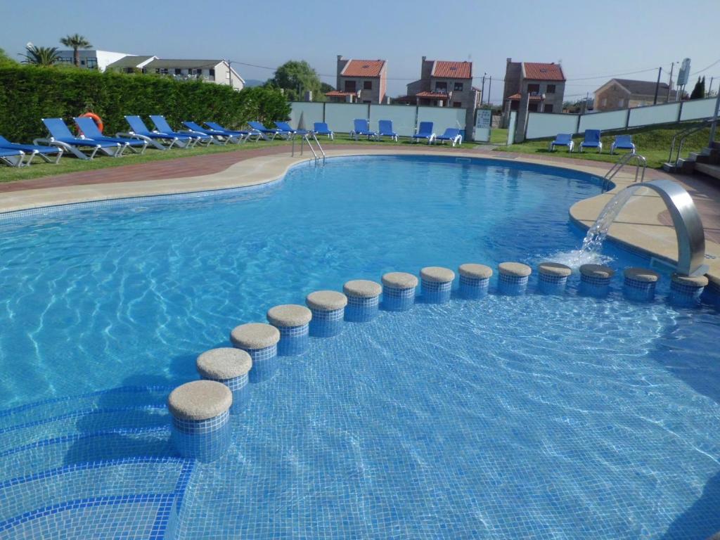 阿兰扎达布里萨酒店的度假村内带蓝色椅子的大型游泳池