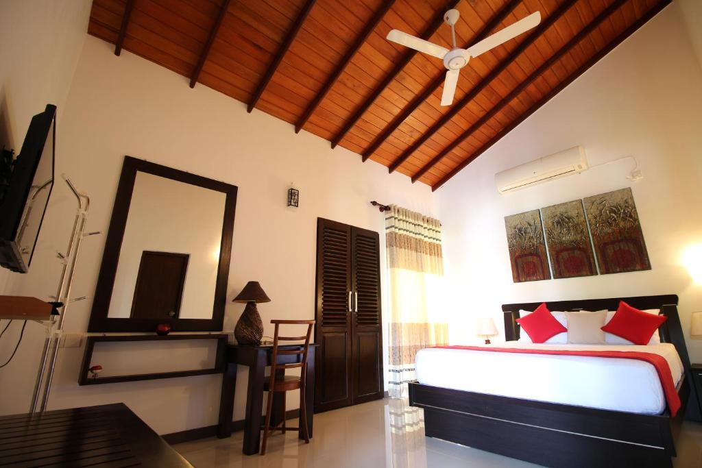 本托塔River Breeze Villa Bentota的一间卧室配有一张床和吊扇
