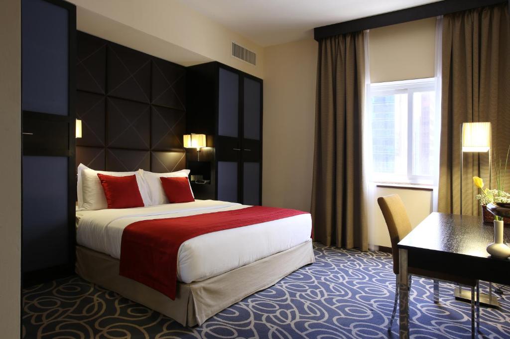 阿布扎比The Eclipse Boutique Suites的酒店客房设有一张大床和一张书桌。