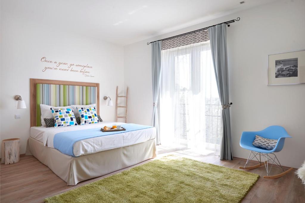 巴拉顿诺尔马迪Villa Millennium的一间卧室配有一张床和一张蓝色椅子