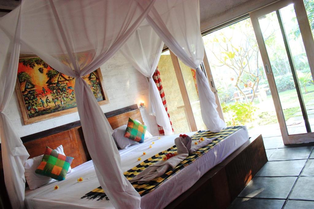 佩母德兰苏堤旅馆的一间带天蓬床的卧室,位于带窗户的房间内