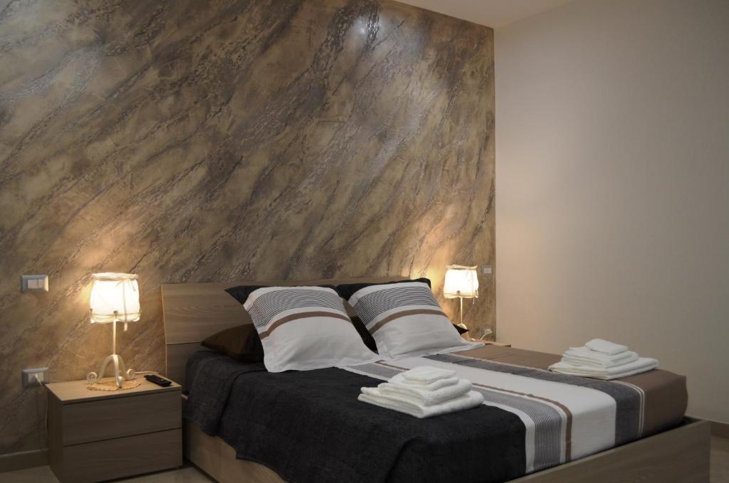 图列Casa Low Cost的一间卧室配有一张带大型木墙的床。