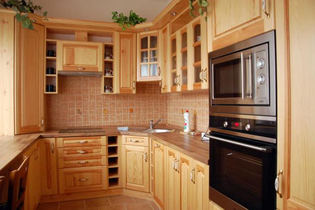 阿德尔什帕赫Apartman Horni Adrspach的厨房配有木制橱柜和黑色用具