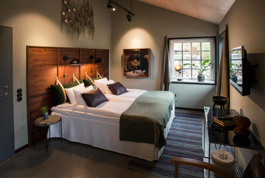 菲斯克拜克希尔Slipens Hotell的一间卧室设有一张大床和一个窗户。