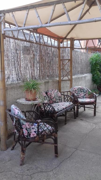 奇尼斯Appartamentino Cinisi的三把椅子和一张桌子,上面有盆栽植物
