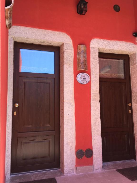 RoccasicuraLa Torre dell'Orologio 2.0的红色建筑一侧的两扇门