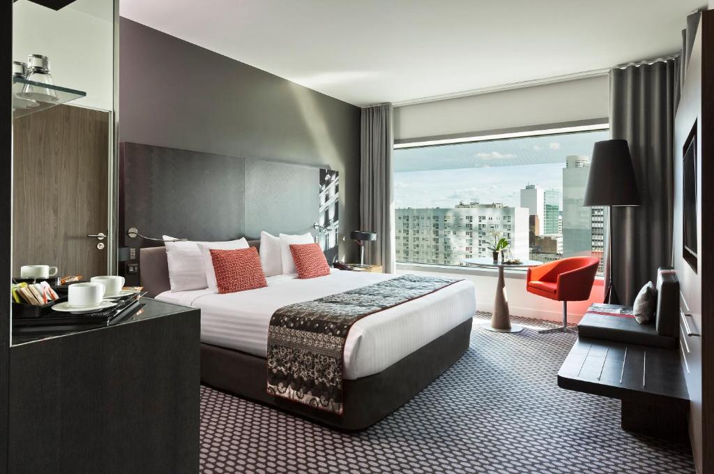 库尔布瓦巴黎狄芬思美利亚酒店的酒店客房设有一张床和一个大窗户