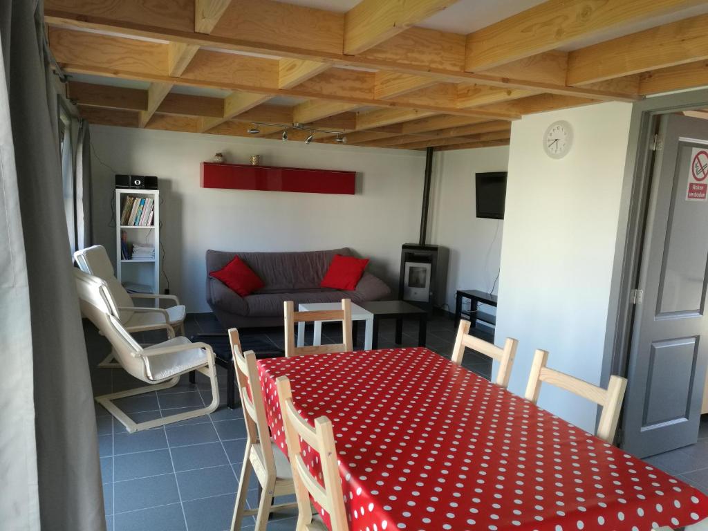 文代讷Wenduine zeehuisje 16的客厅配有红色的桌子、椅子和沙发