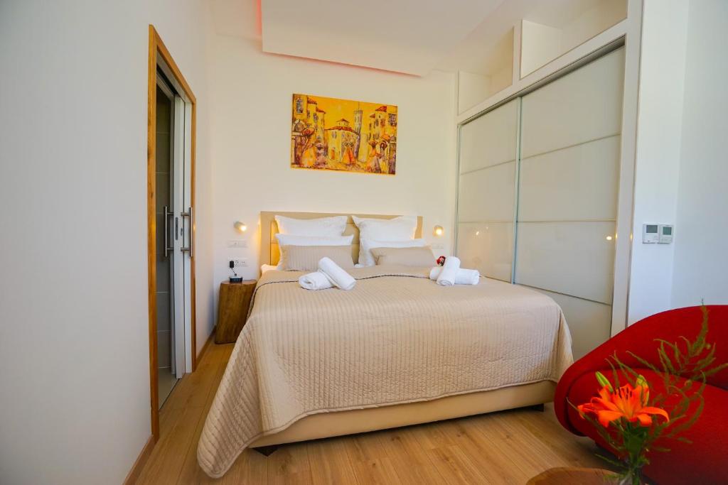 扎达尔Destino City Apartments的一间卧室配有一张大床和一张红色椅子