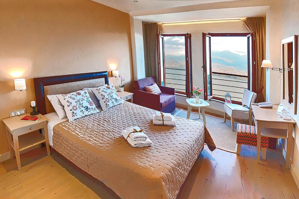 约阿尼纳Arktos Hotel的一间带一张大床和一张书桌的卧室和一间带书桌的房间