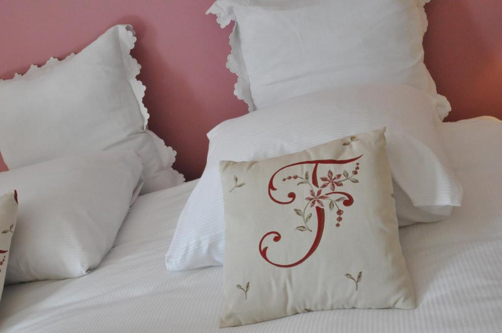 Louftémont皮尔罗伊贝赫尔B＆B酒店的一张带白色枕头的床,上面有红色的设计