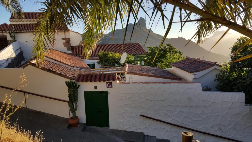 克鲁兹·德·特赫达桑塔纳塞古拉之家旅馆的一座白色的房子,有绿门和棕榈树