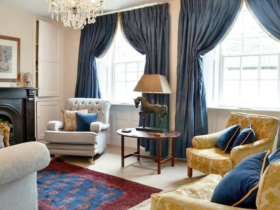 科尔福德Pomegranate的客厅配有蓝色窗帘、沙发和桌子