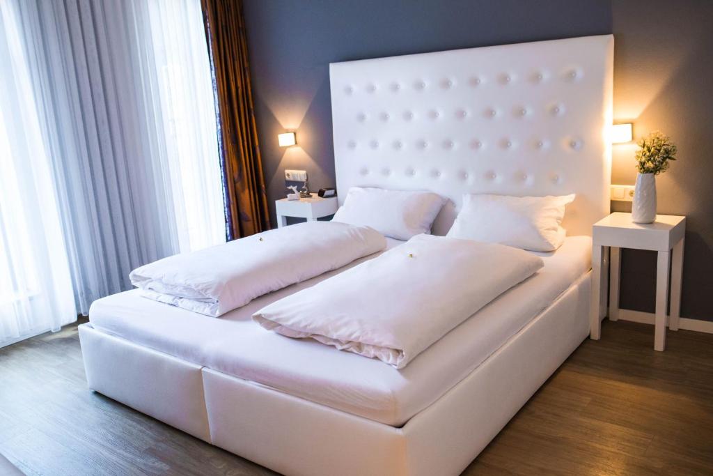 因戈尔施塔特住宿酒店的一张白色的床,上面有两个枕头
